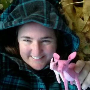 Happy crafting closeup of woman with 2 pink 100% wool felt handmade deer in hand.